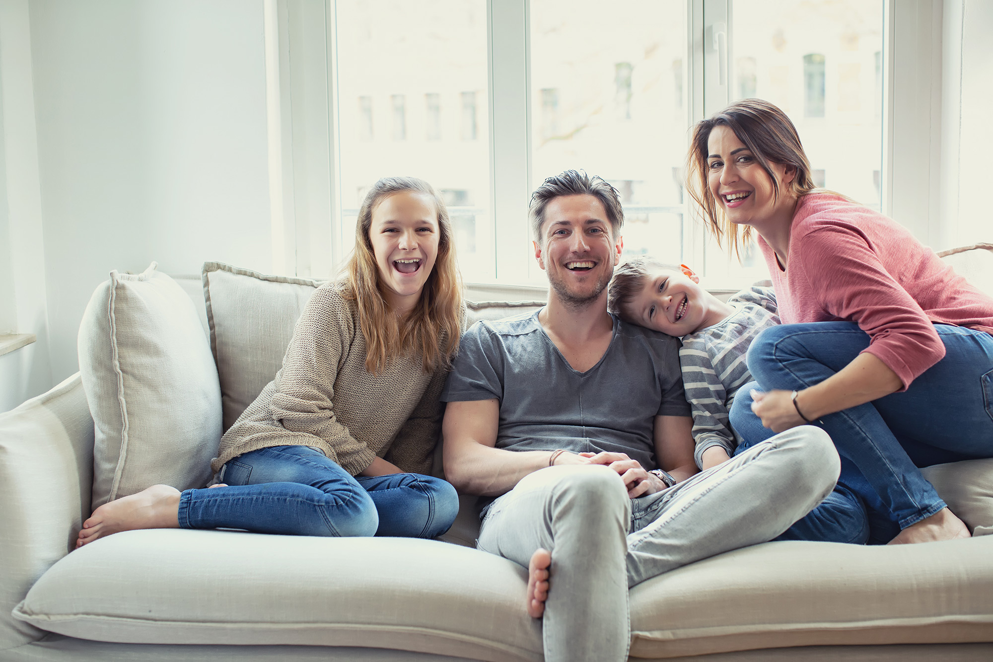 Happy family on couch enjoying a comfortable, sustainable home