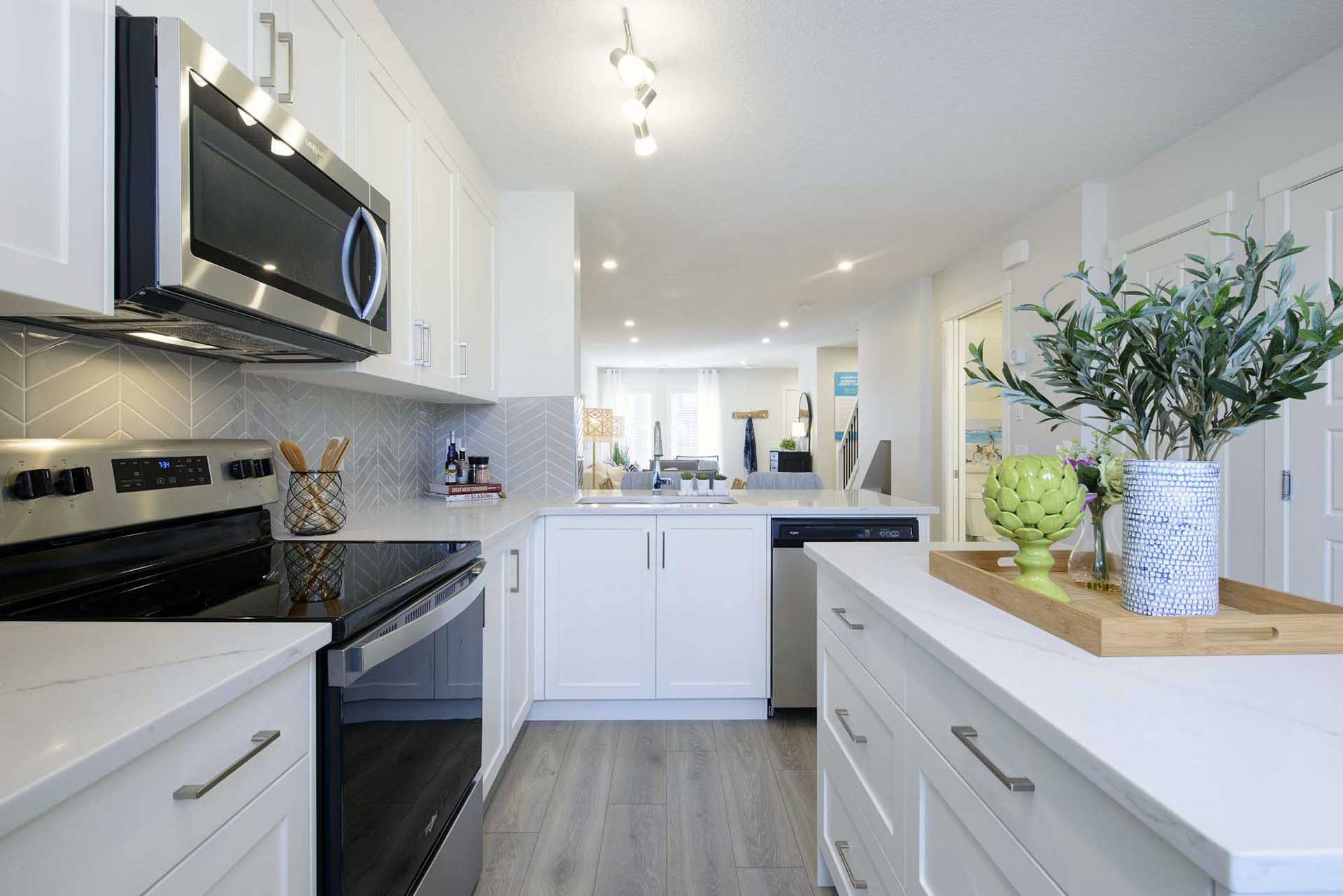 Kitchen with white cabinets, white quartz countertop and stainless steel appliances.