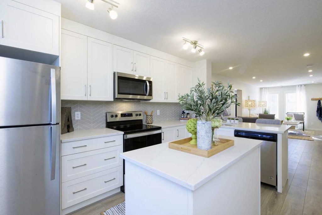 Kitchen with white cabinets, white quartz countertop and stainless steel appliance