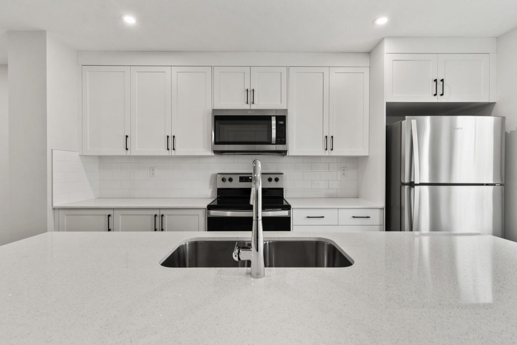 ZEN Livingston Ambrosia floorplan kitchen interior featuring white cabinetry and a large kitchen island.