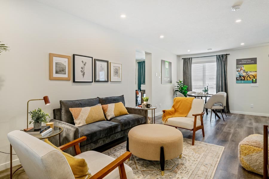 Cozy living room in an Avalon Homes Net Zero townhome in Calgary featuring mid-century modern furniture, decor, and natural light