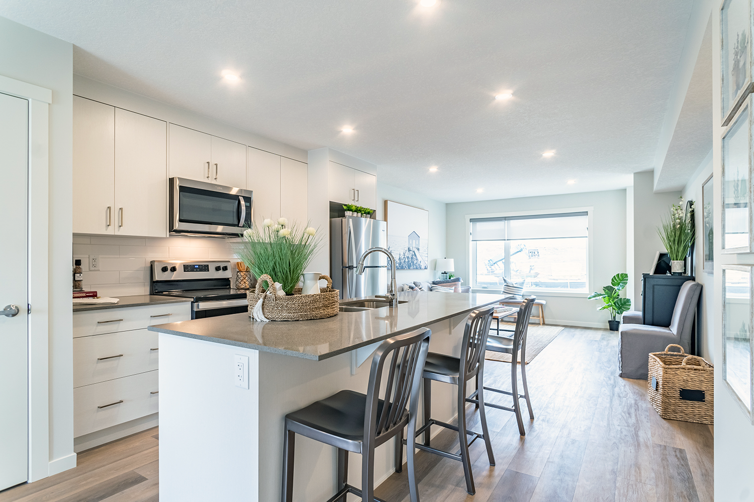 Rental townhome with white kitchen cabinets, island and large window in the background.