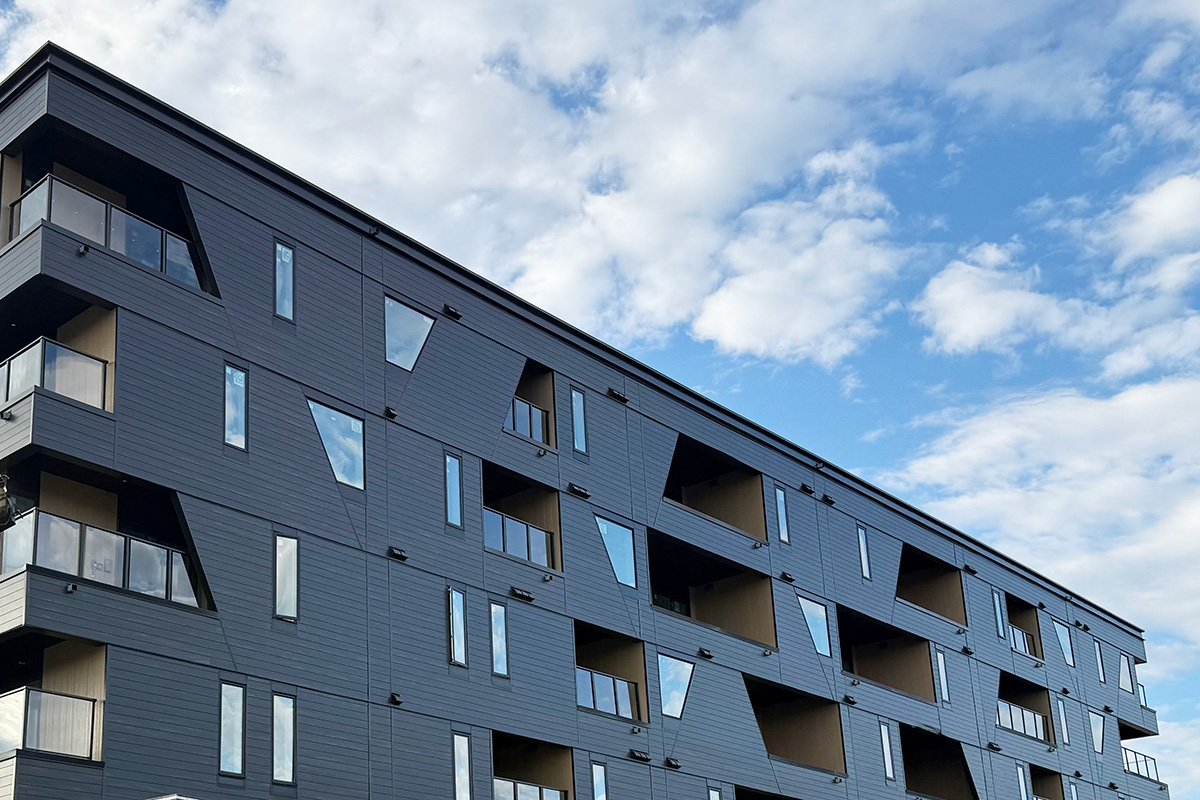 Dark building exterior with patios and windows again a blue sky