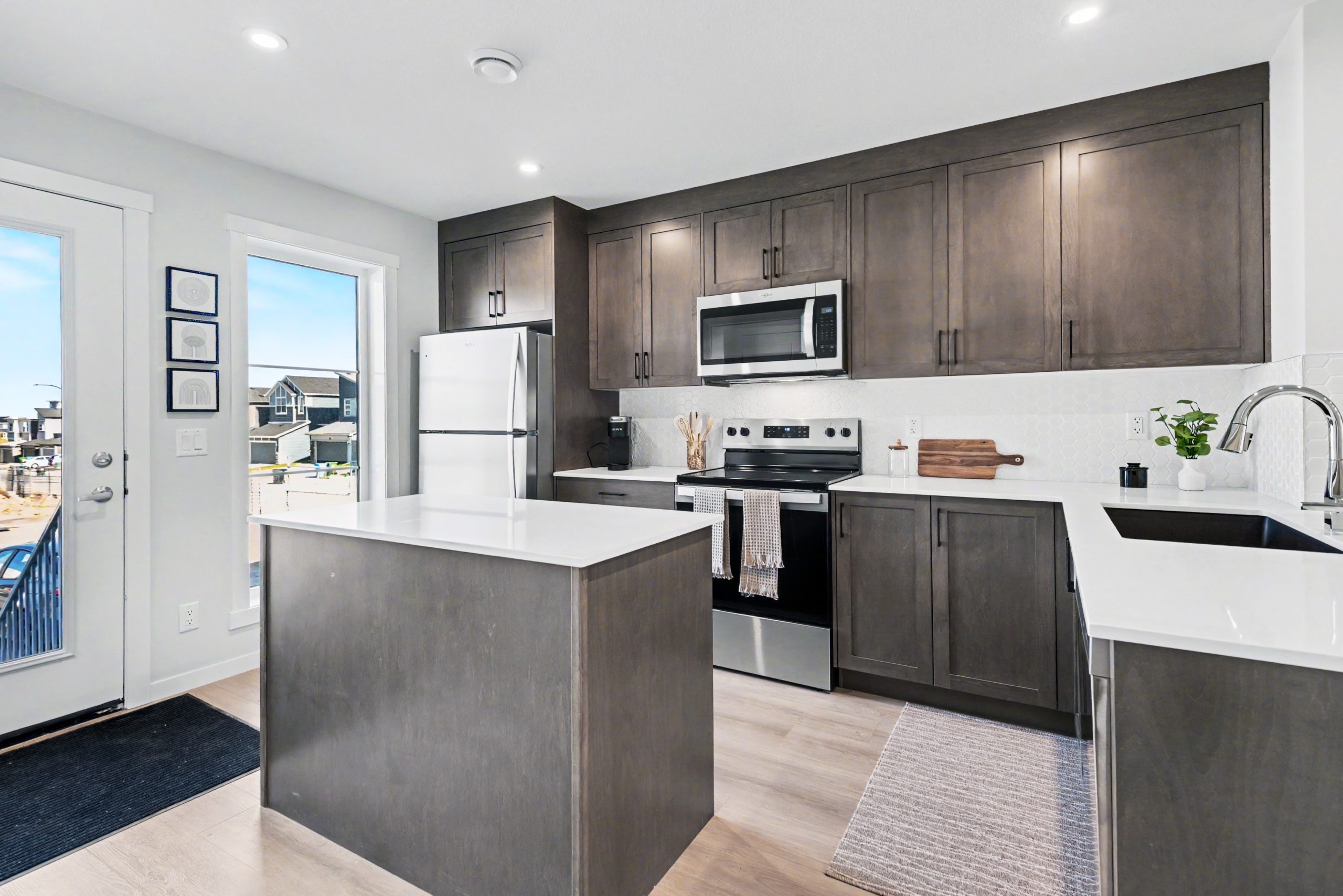 kitchen with beautiful brown cabinets, white countertops and light brown Luxury Vinyl plank flooring.